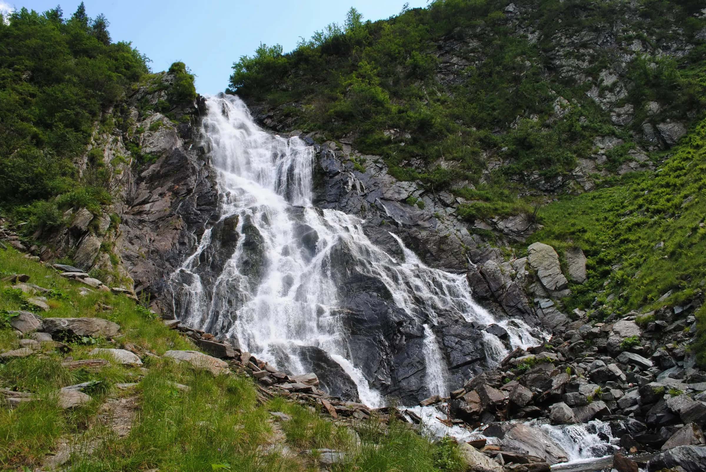 La cascata di Bâlea che scende sulle rocce in una valle verde