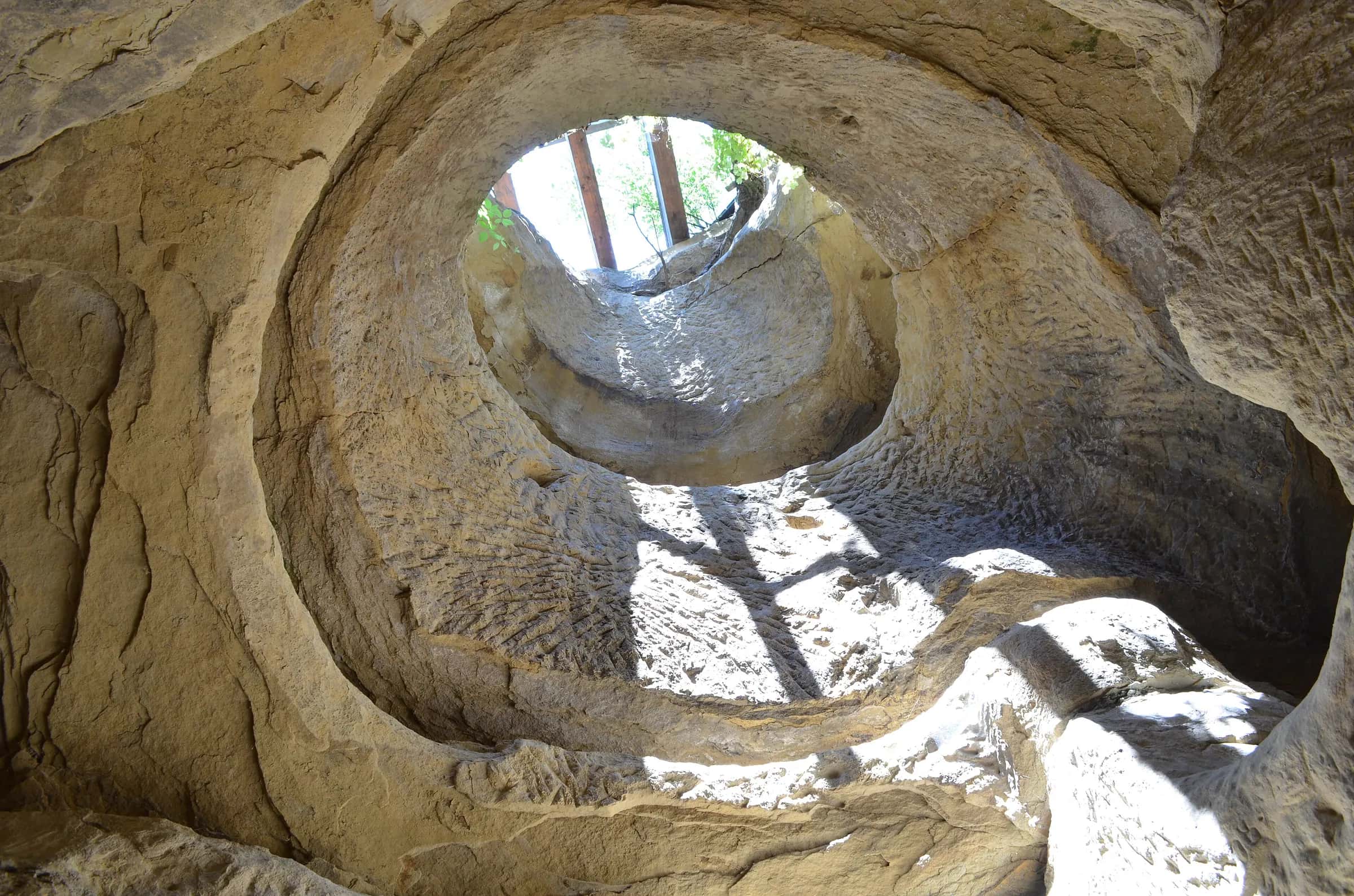 La luce del giorno che filtra dall'apertura circolare della cappella rupestre di Șinca Veche