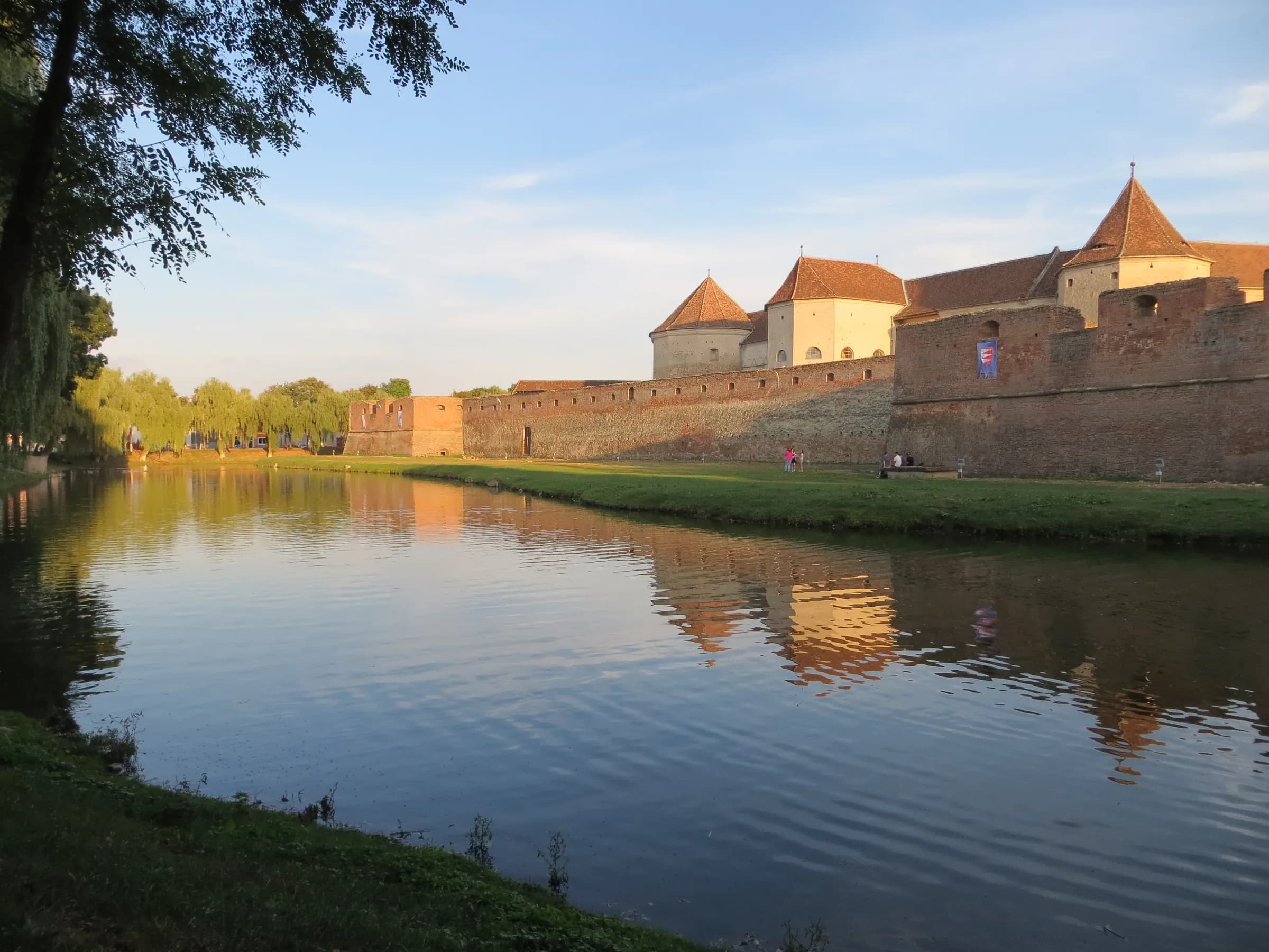 Cetatea Făgăraș și șanțul său cu apă, în lumina serii